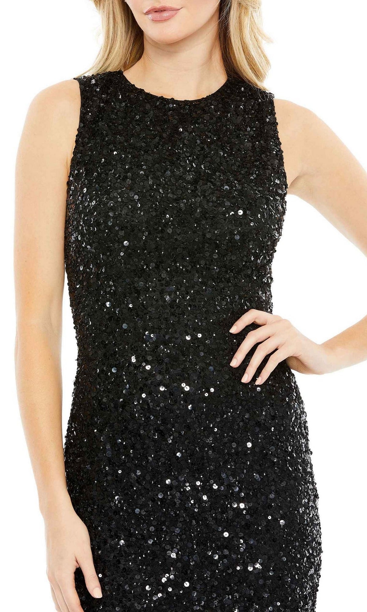 A woman wears the Short Semi-Formal Dress 5597 by Mac Duggal, a sleeveless black sequin dress with a high neck, one arm bent at the waist and the other resting by her side.